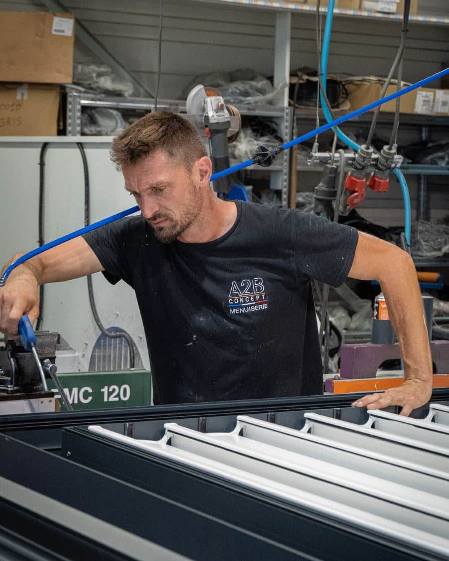 Menuisier aluminium A2B Concept au poste d'usinage dans l'atelier