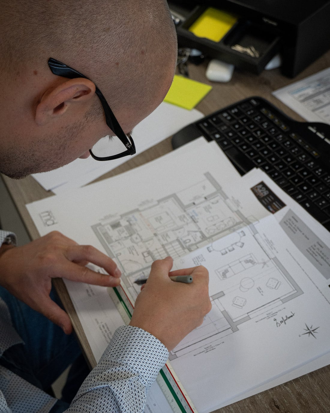 Corentin d'A2B Concept annotant les plans d'un projet de menuiserie