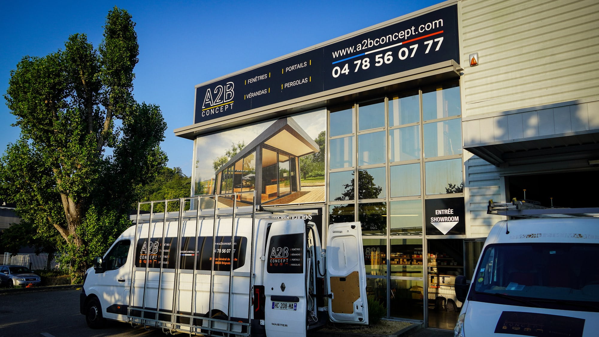 Façade du showroom et de l'atelier A2B Concept à Brignais, avec les camions de pose